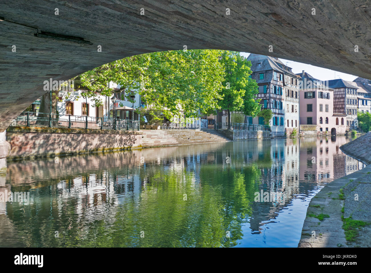 STRASBOURG THE PETITE FRANCE DISTRICT AND RIVER L'ILL VIEW UNDER BRIDGE OVER ONE OF THE RIVER CHANNELS AND PASTEL COLOURED HOUSES Stock Photo