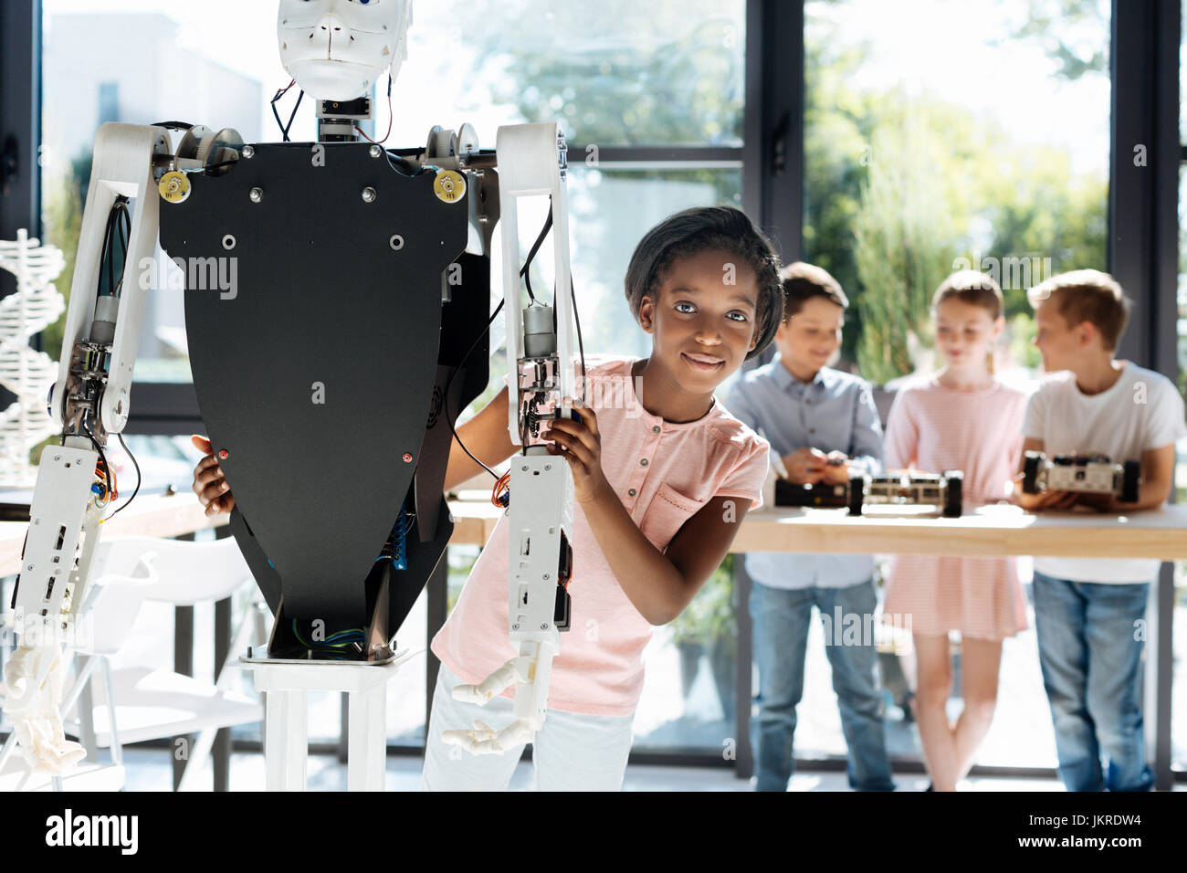 Pretty girl hugging a human robot from behind Stock Photo