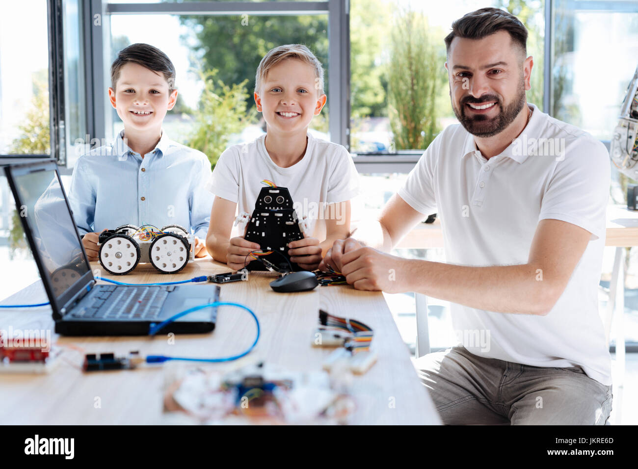 Teacher and his students posing during robotics workshop Stock Photo