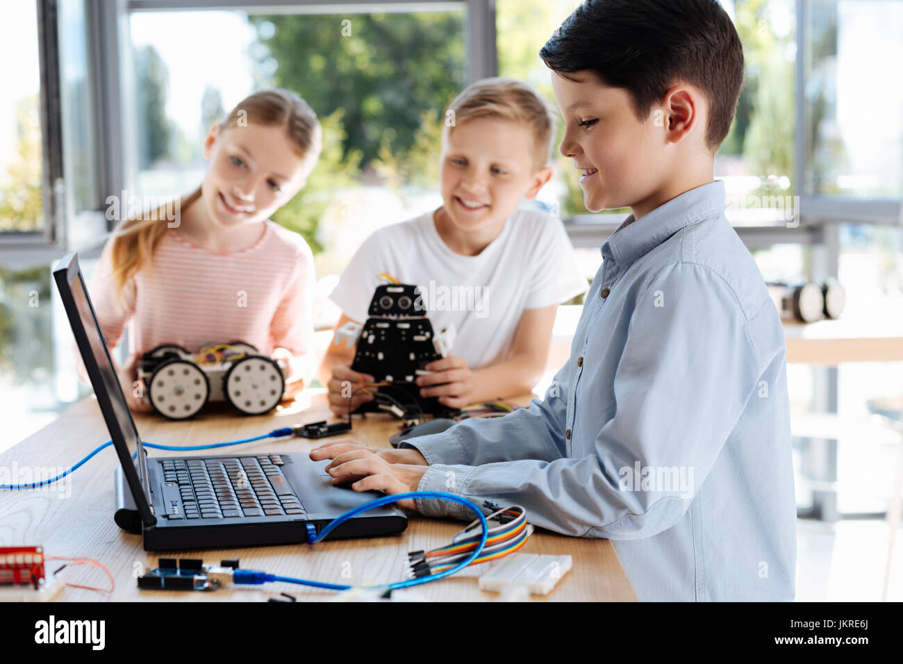 Lovely boy changing settings of a robot on laptop Stock Photo