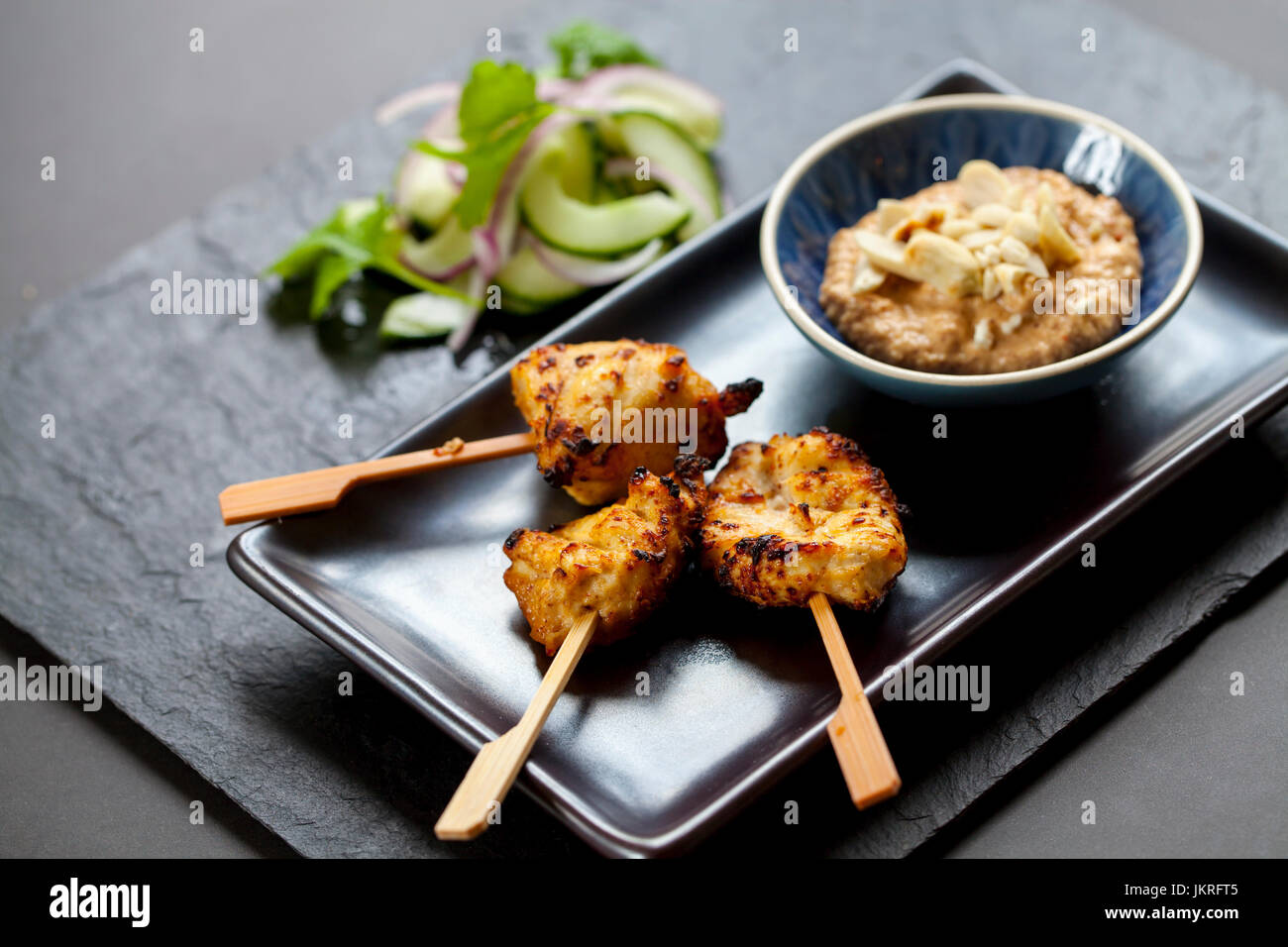 chicken satay and onion and cucumber salad Stock Photo