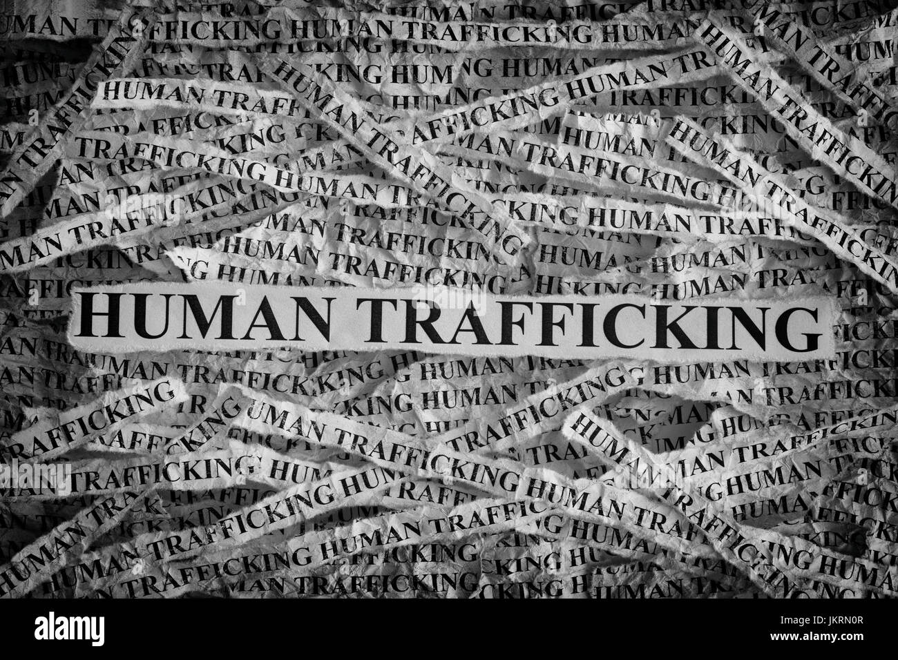 Human Trafficking. Torn pieces of paper with the words Human Trafficking. Concept Image. Black and White. Closeup. Stock Photo