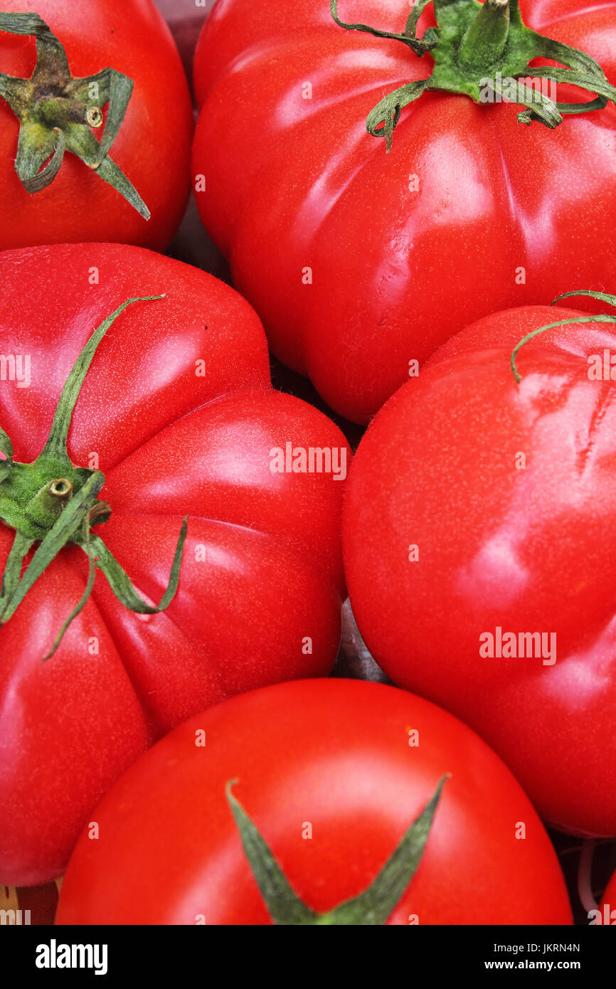 Tomato texture. Fresh big red tomatoes closeup background photo. Pile of tomatoes. Tomato pattern with studio lights. Stock Photo