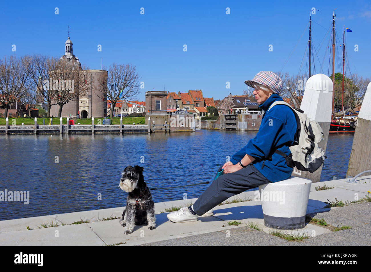 Woman with Miniature Schnauzer, black-silver, at harbour, Enkhuizen, Netherlands / Defence tower 'Dromedaris' Stock Photo