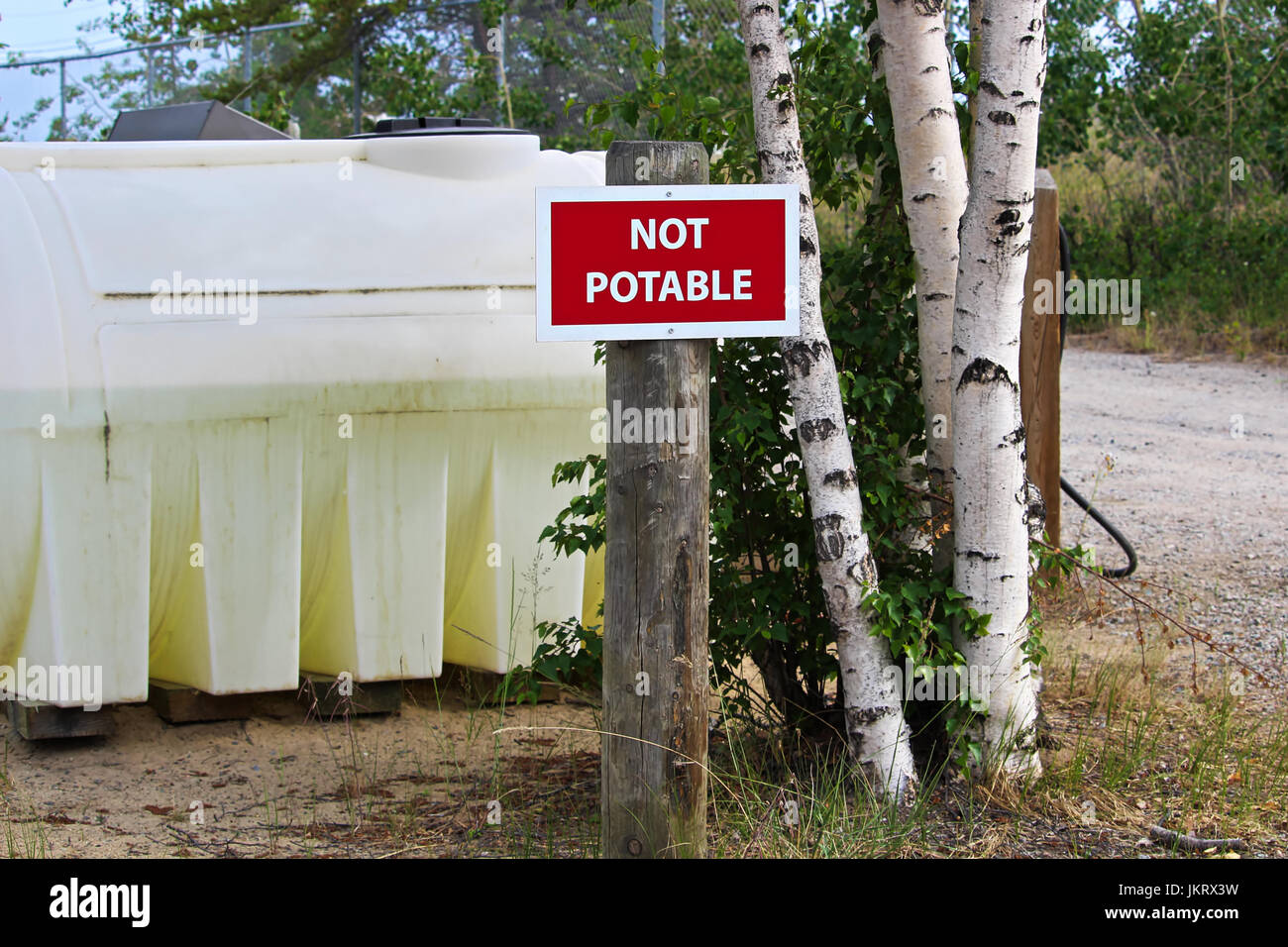 A not potable sign next to a water holding tank. Stock Photo