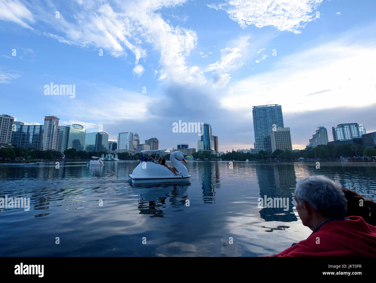 Swan shaped paddle boats at Lake Eola Park with the downtown Orlando skyline in the background on the Fourth of July. Stock Photo