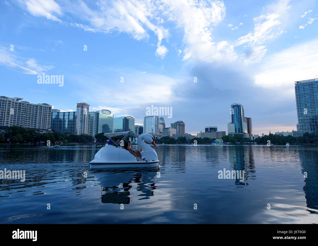 Swan shaped paddle boats at Lake Eola Park with the downtown Orlando skyline in the background on the Fourth of July. Stock Photo