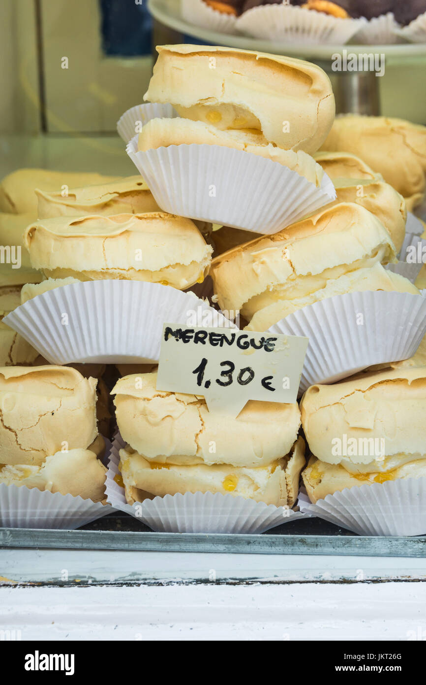 Pile of homemade baked meringues on a cake stand in display window of artisan bakery in a European city, Spain Stock Photo