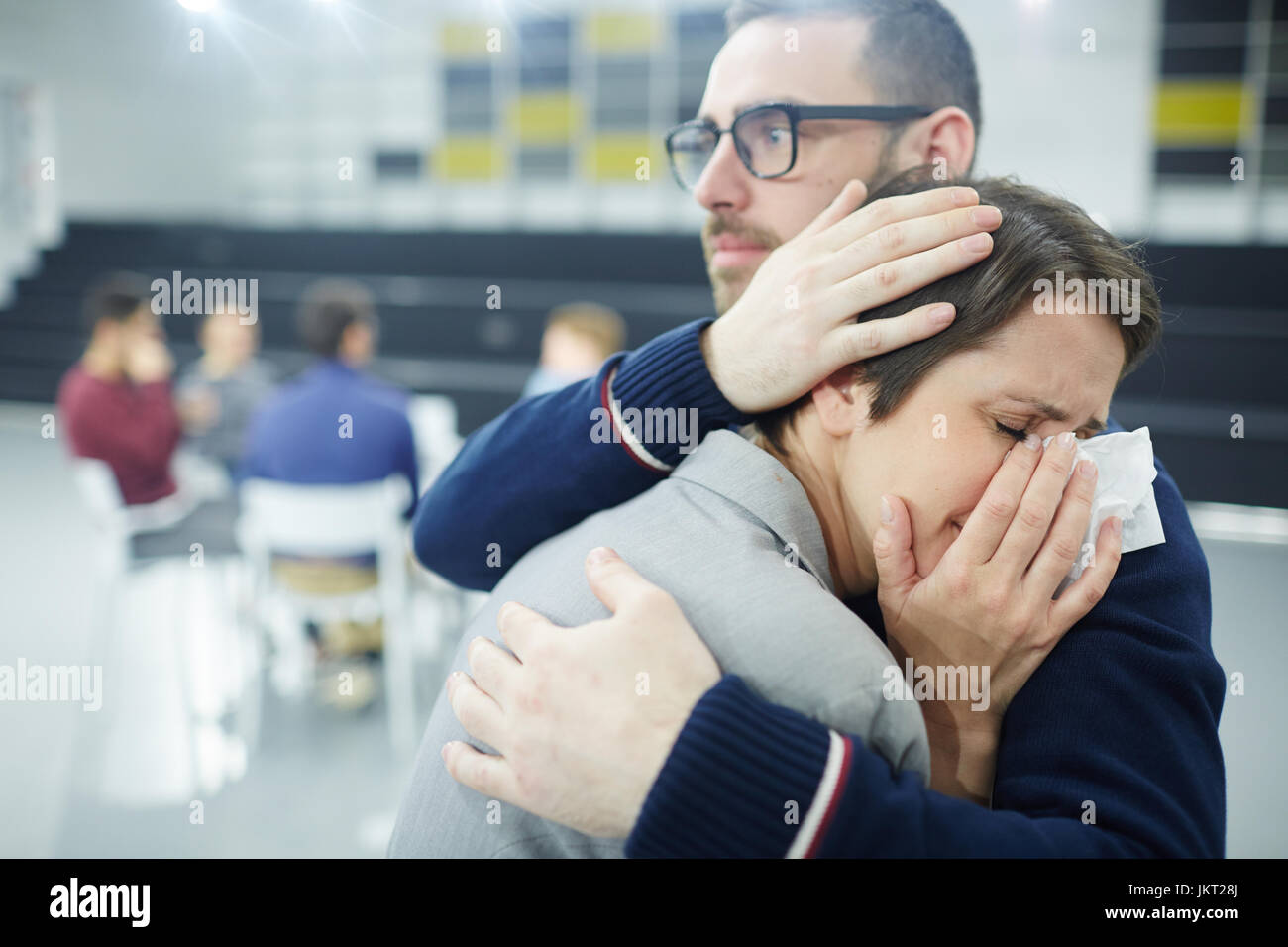 Desperate female crying on man shoulder Stock Photo