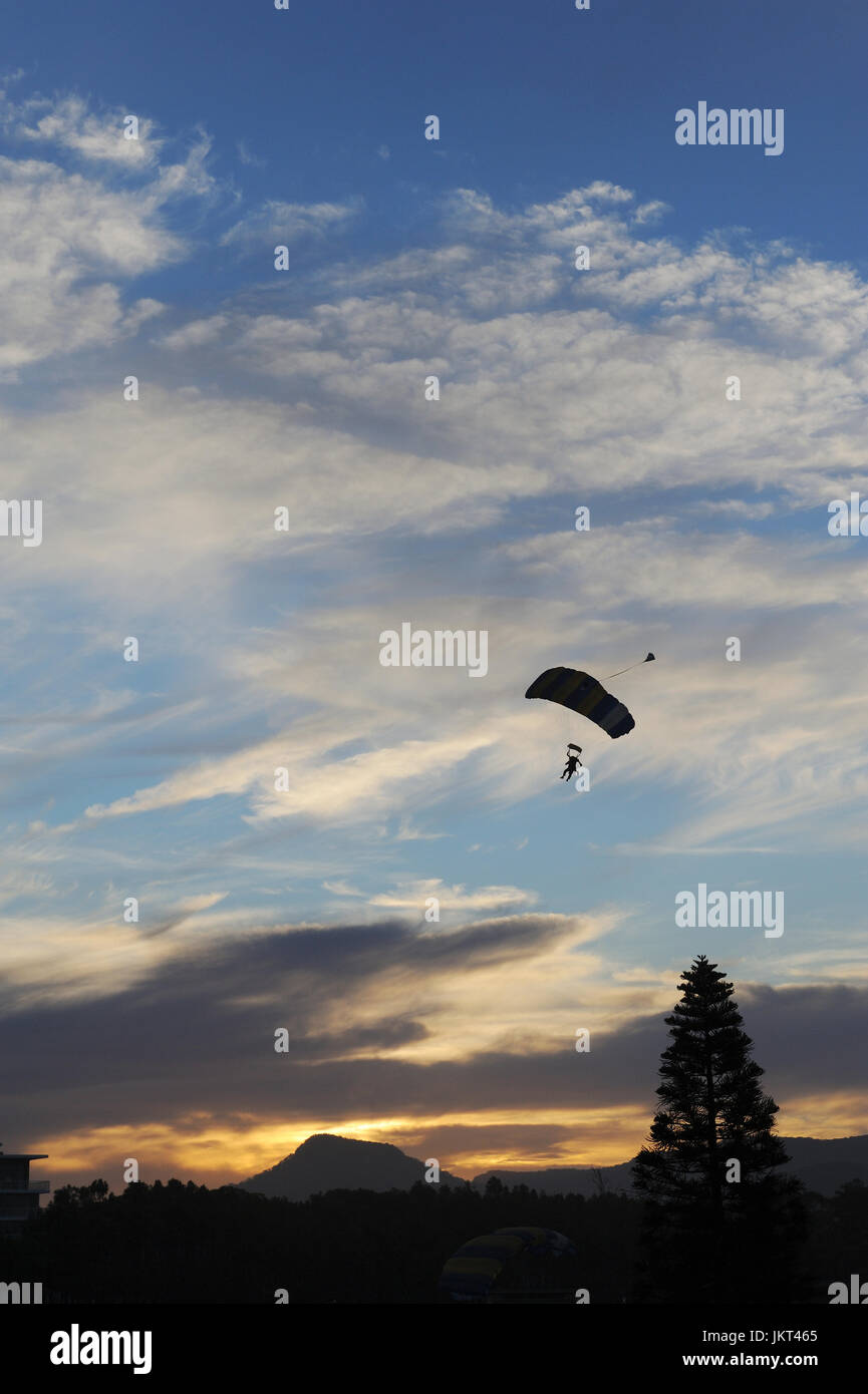 Hang glider gliding down with parachute with mountain in background