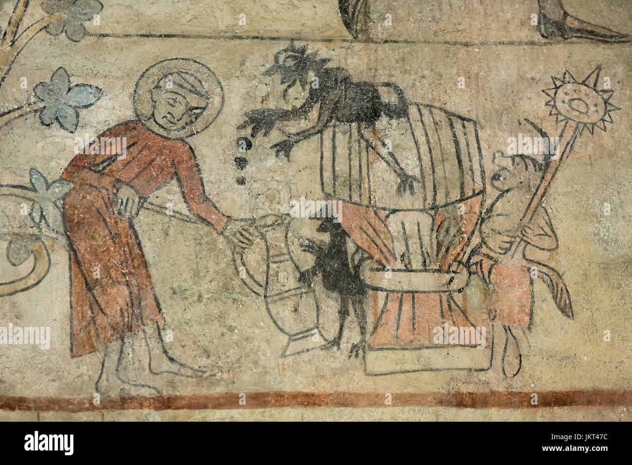 Danish medieval religious fresco from the 14th century in Romanesque style Oerslev Church showing a monk drawing off beer from a keg while devils are  Stock Photo