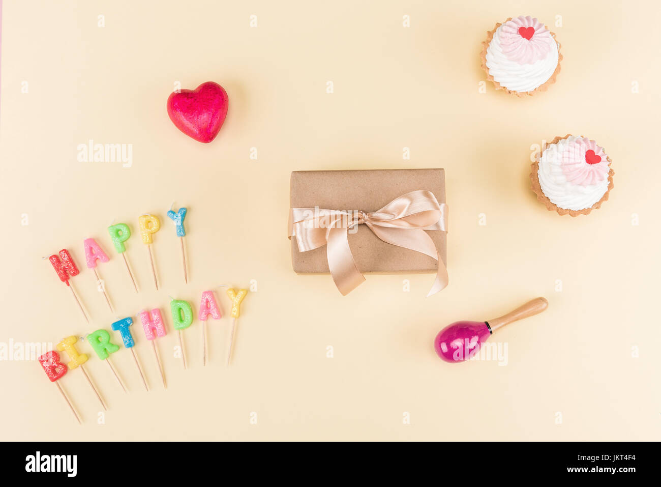 Top view of happy birthday lettering, envelope with ribbon and delicious cupcakes on pink, birthday party concept Stock Photo