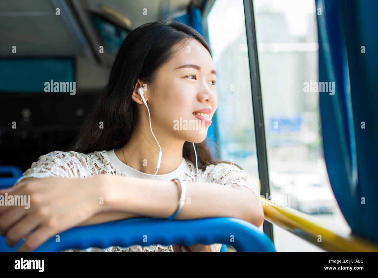 Girl listening to music on a public bus ride Stock Photo