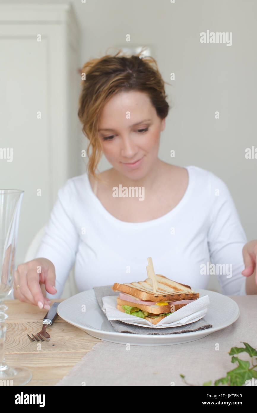 Woman is going to have breakfast with a sandwich Stock Photo