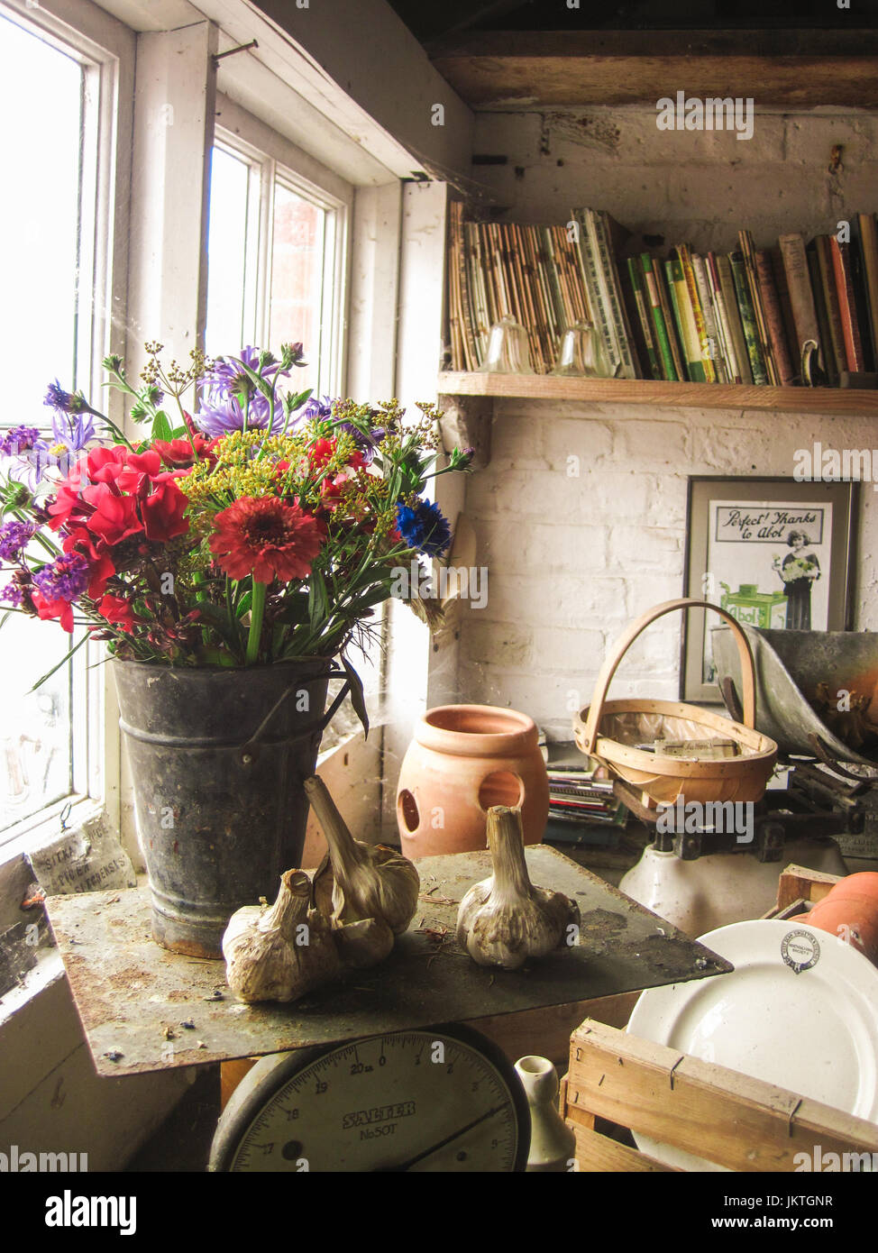 Interior of rustic shed with stacked terracotta plant pots and vintage gardening tools Stock Photo