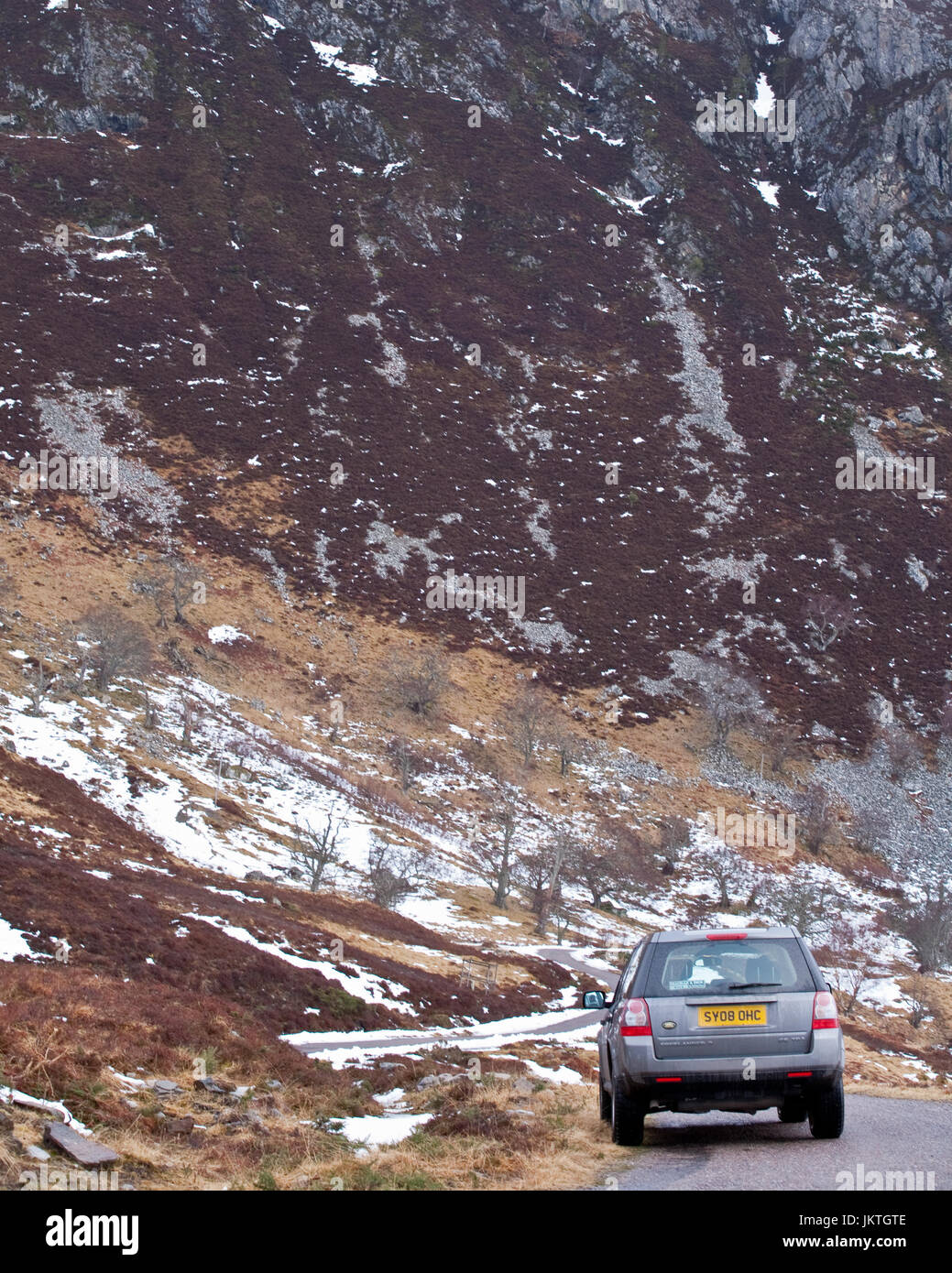 Land Rover Freelander against snowy mountain, rear view Stock Photo