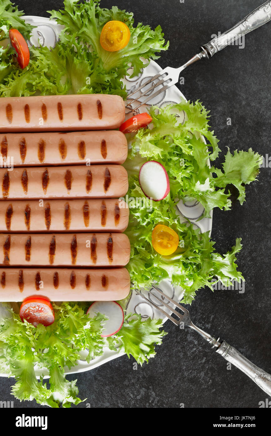 Half plate with grilled wurst and fresh salad, photographed from above, vertical composition. Stock Photo
