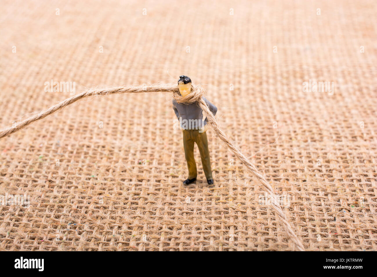 Figurine man with a rope on the neck Stock Photo - Alamy