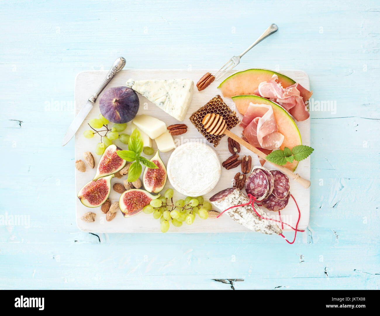 Wine snack set. Figs, grapes, nuts, cheese variety, meat appetizers and herbs Stock Photo