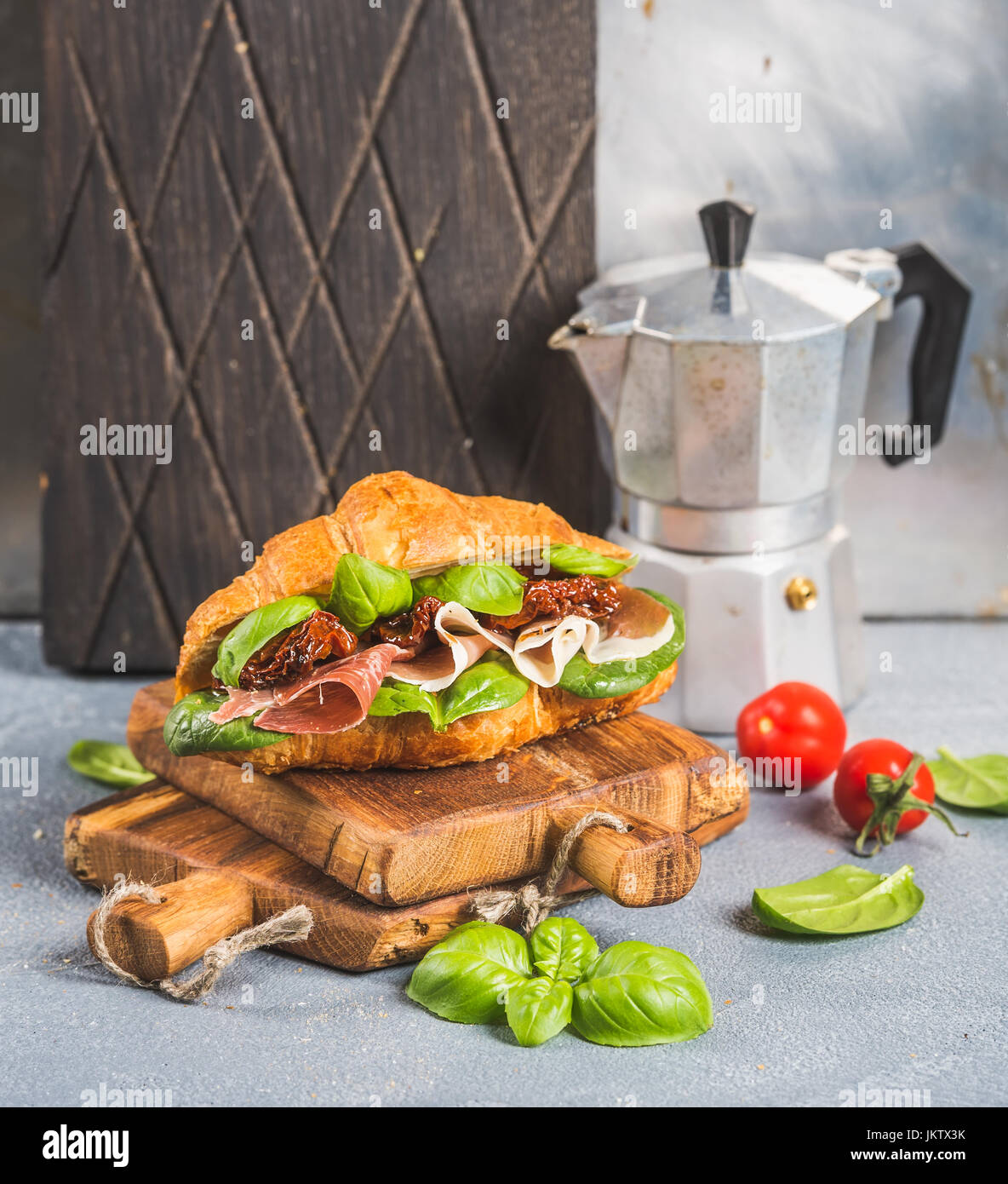 Croissant sandwich with smoked meat Prosciutto di Parma, sun dried