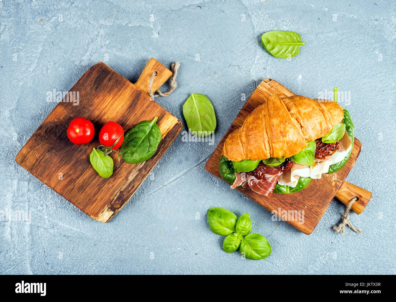 Croissant sandwich with smoked meat Prosciutto di Parma, sun dried