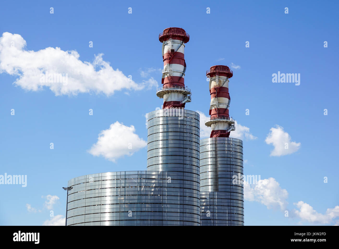 Industrial plant stacks with blue sky and a few clouds Stock Photo - Alamy