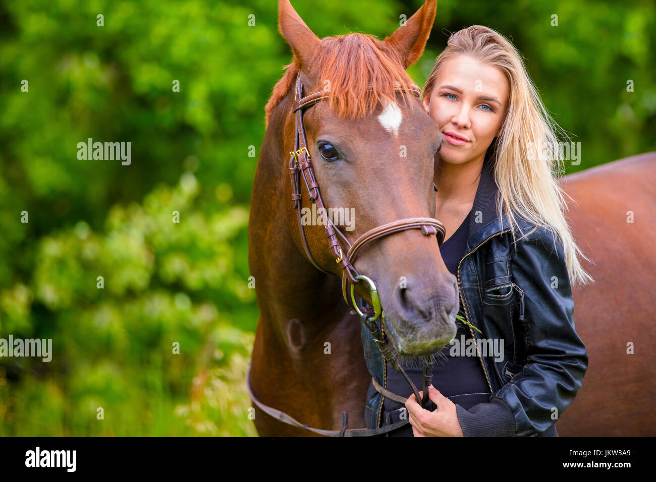 Beautiful smiling woman with her arabian horse in the field Stock Photo