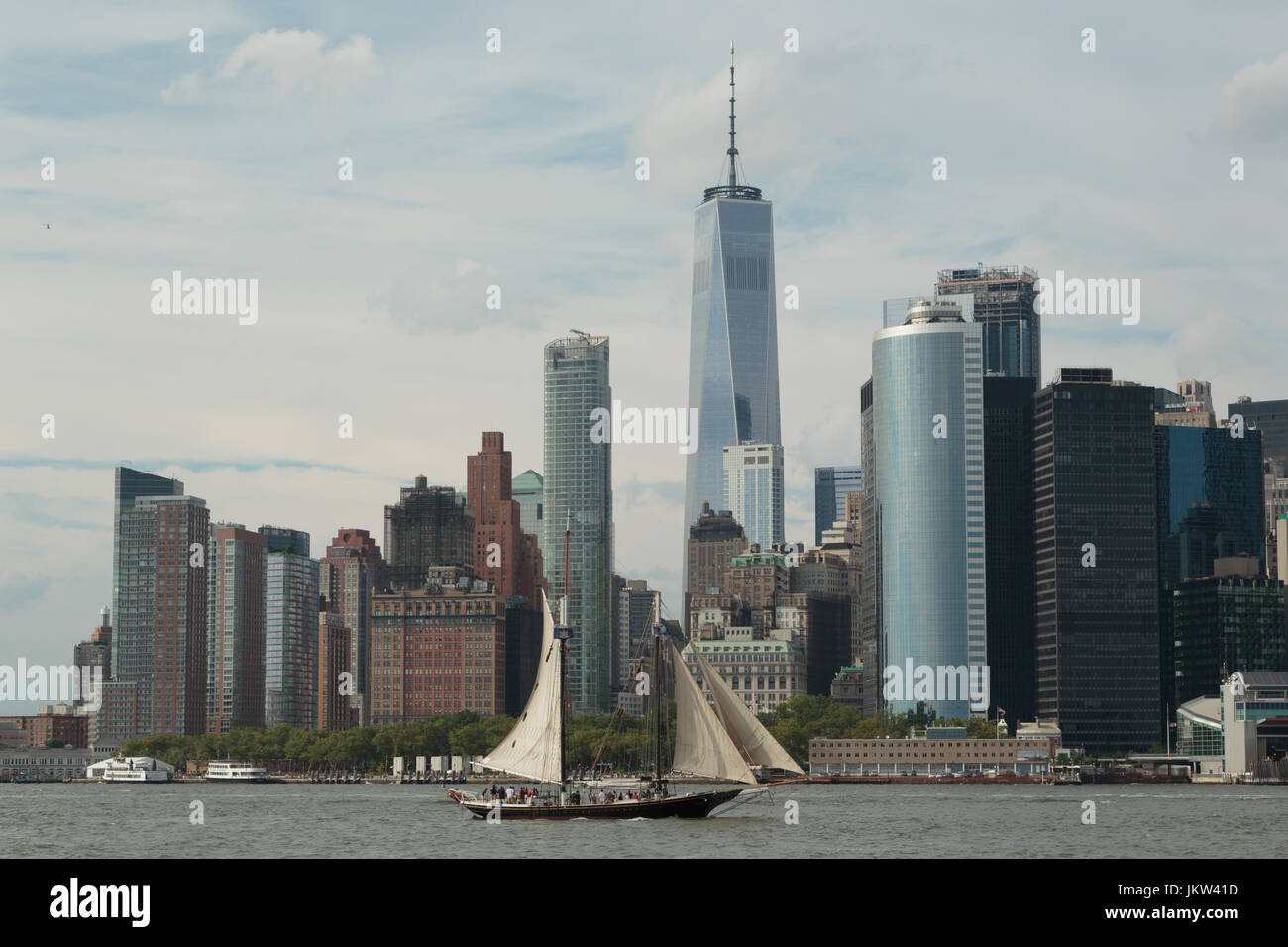 A photograph of an old sailing ship sailing past the Manhattan skyline, as seen from Governor's Island, New York City. Stock Photo