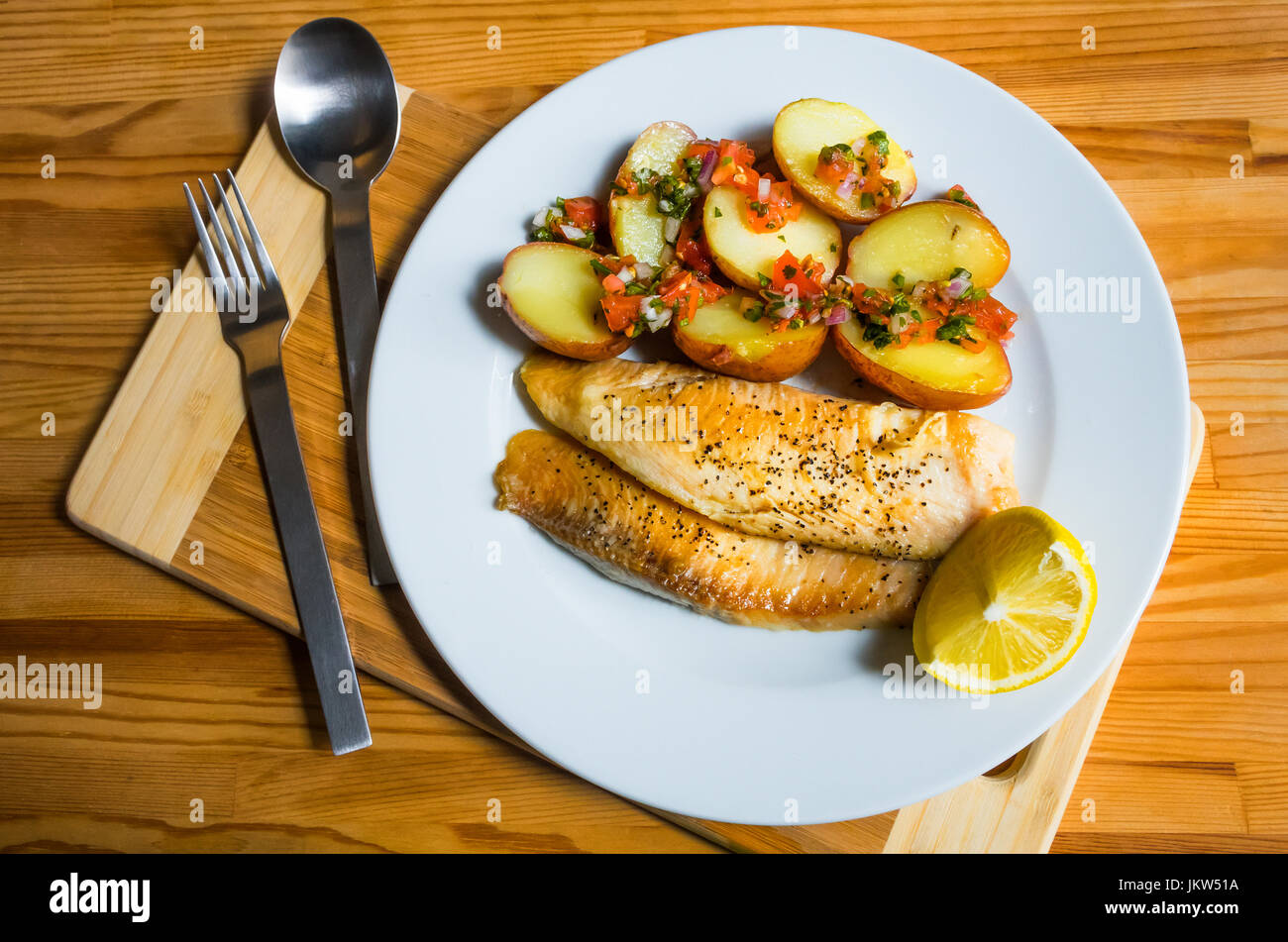 Grilled tilapia fillets with sautéed potatoes, salsa and lemon Stock