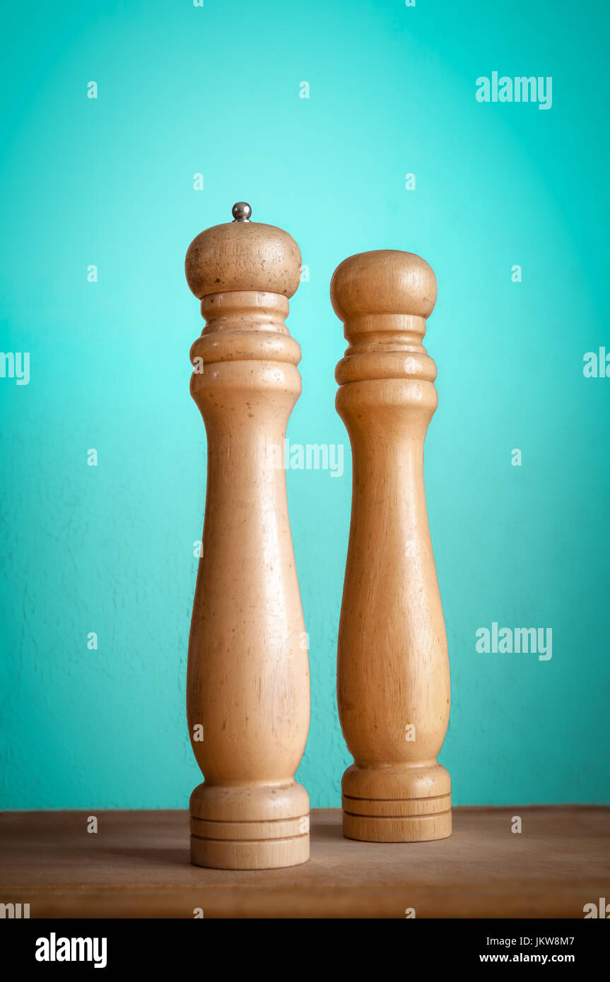 Wooden salt shaker and pepper mill on wooden board with uncluttered background. Stock Photo