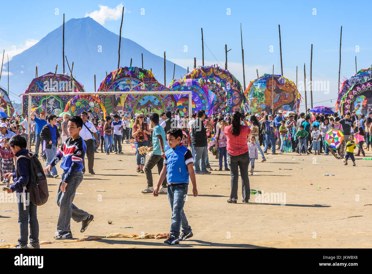Sumpango, Guatemala - November 1, 2015: Visitors at giant kite festival  on All Saints' Day or Day of the Dead. Agua volcano behind. Stock Photo