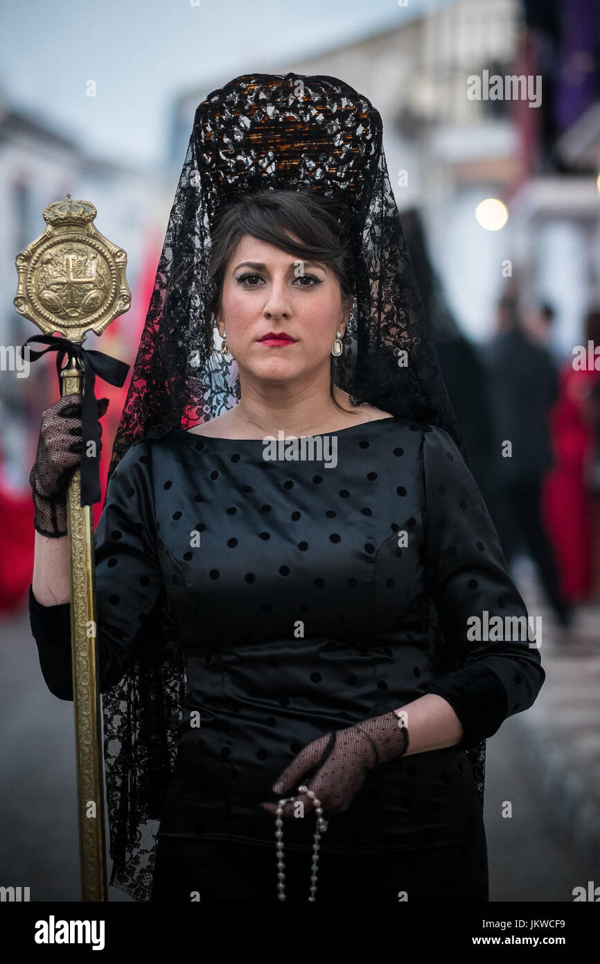 Some members from the brotherhood Christ of Blood and the Holy Burrial dress in a traditional mourning outfit called Mantilla during the procession that takes place in Arriate on Holy Saturday. The village of Arriate counts with about forur thousand inhabitants, a mainly agricultural village close to Ronda. The Easter celebrations are something very important in the village, a proove of it is that there are two brotherhoods that count with numerous members and compete between echeother with their sumptuous parades that have nothing to envy from those you may find in Seville or Malaga. Stock Photo