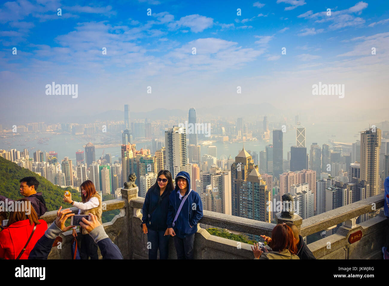 HONG KONG, CHINA - JANUARY 22, 2017: Unidentified people taking pictures from Victoria Peak to the city of Hong Kong in the horizont in a sunny day wi Stock Photo