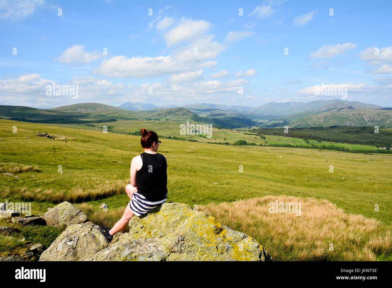Woman taking in the view northwards of the Lake District taken near Lowick in Cumbria England Stock Photo
