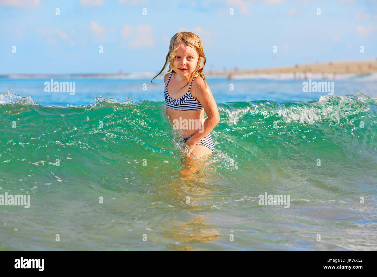 Happy family lifestyle. Baby girl splashing and jumping with fun in