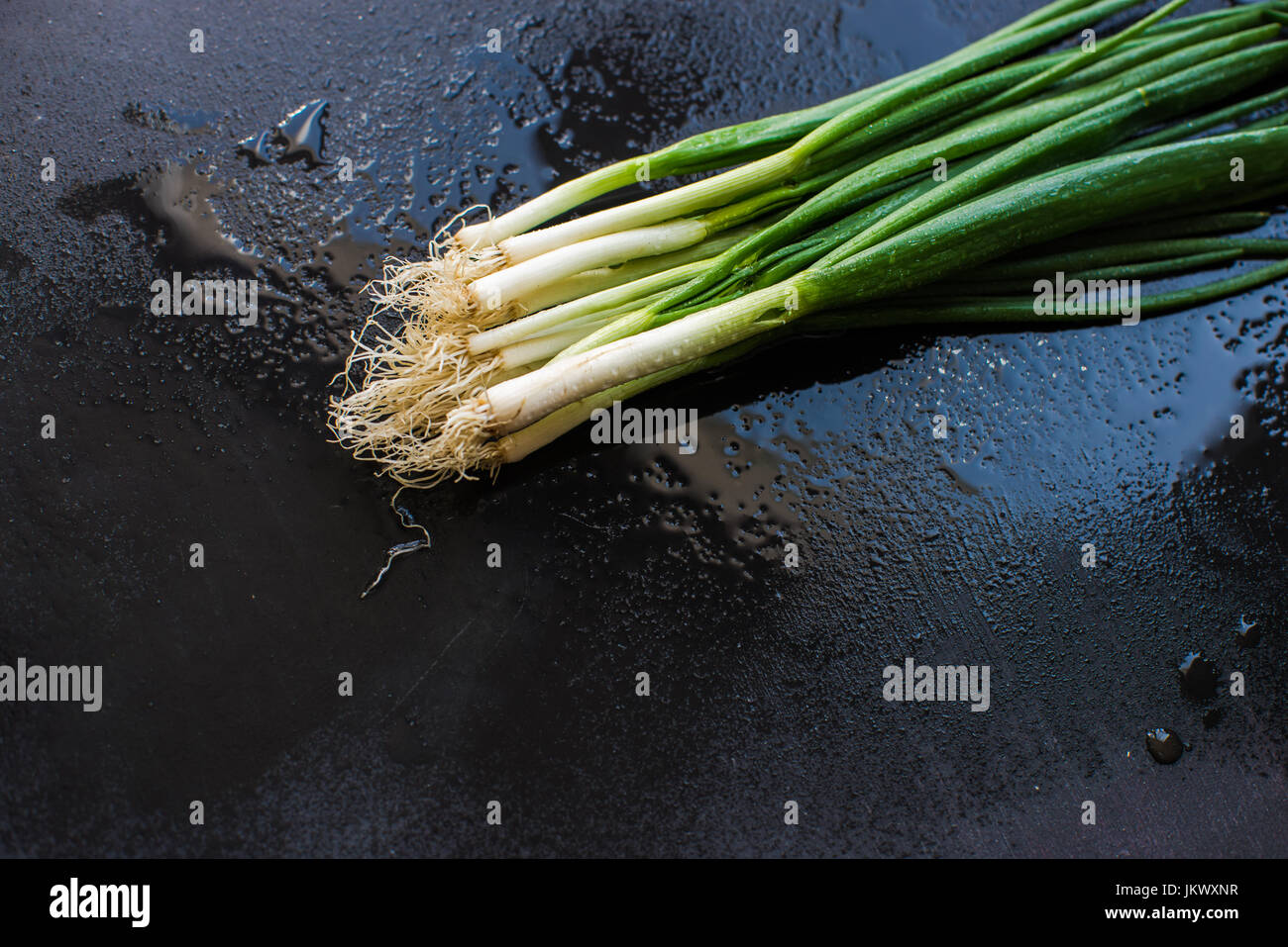 Organic green onion on dark board Stock Photo - Alamy