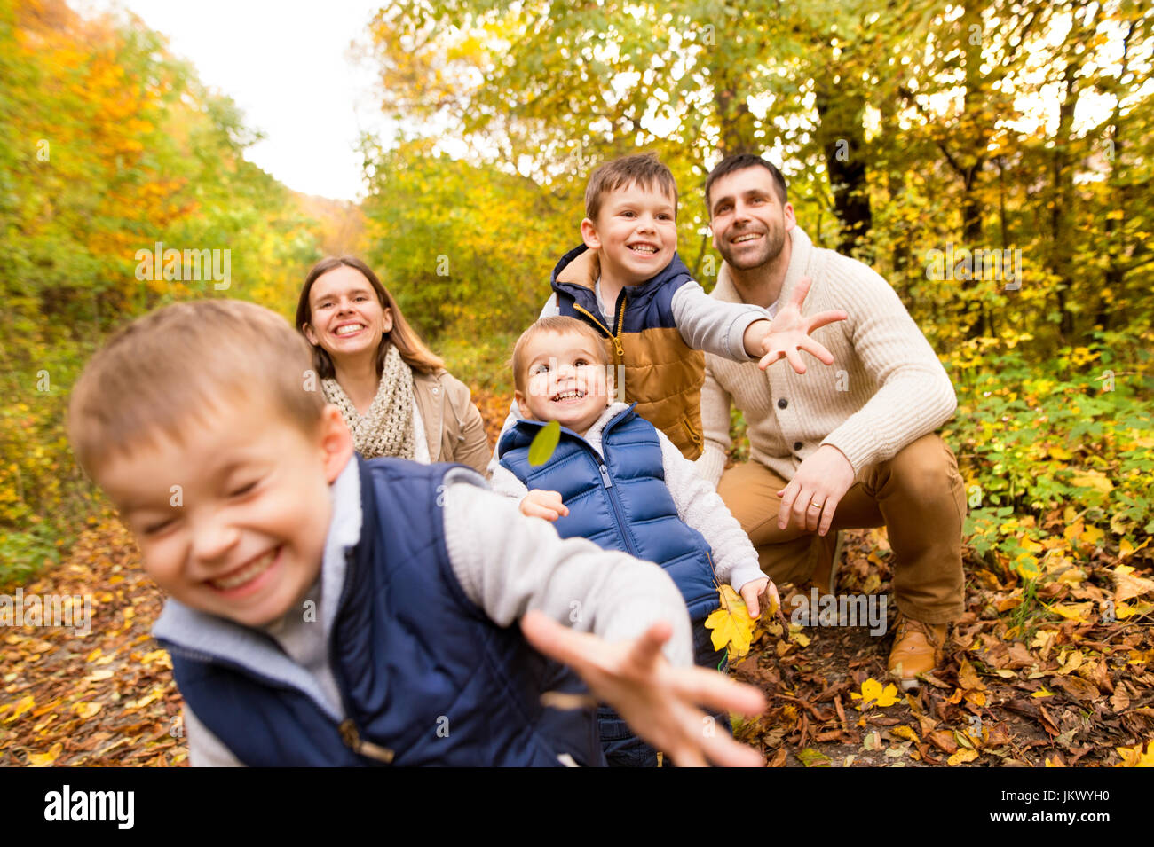 Beautiful young family on a walk in autumn forest Stock Photo - Alamy