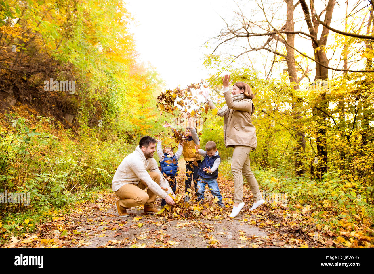 Beautiful young family on a walk in autumn forest Stock Photo - Alamy