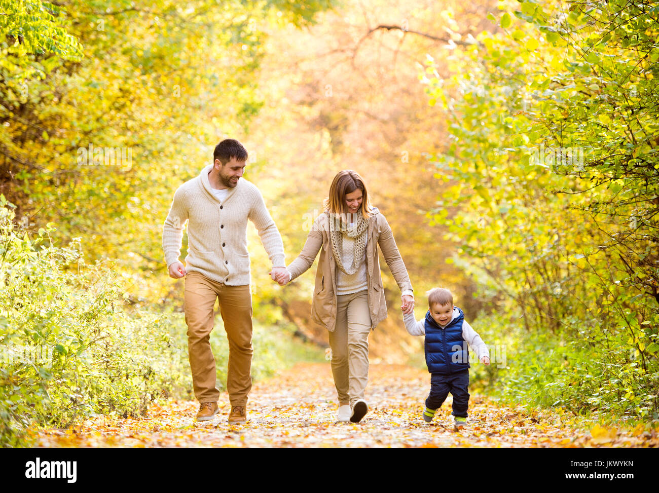 Beautiful young family on a walk in autumn forest Stock Photo - Alamy