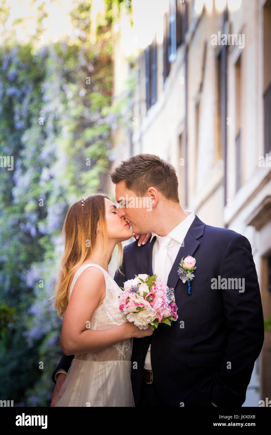 Bride and groom posing on the old streets of Rome, Italy Stock Photo ...