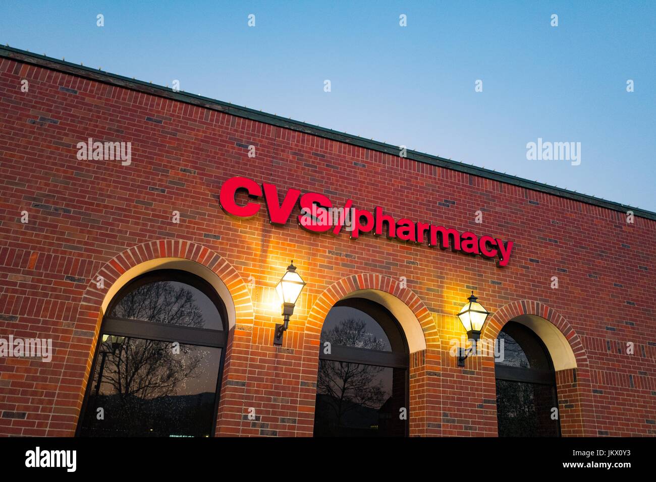 Facade of a CVS Pharmacy, with a brick exterior, lit by two antique-style lamps at night, in the San Francisco Bay Area town of San Ramon, California, March 30, 2017. Stock Photo