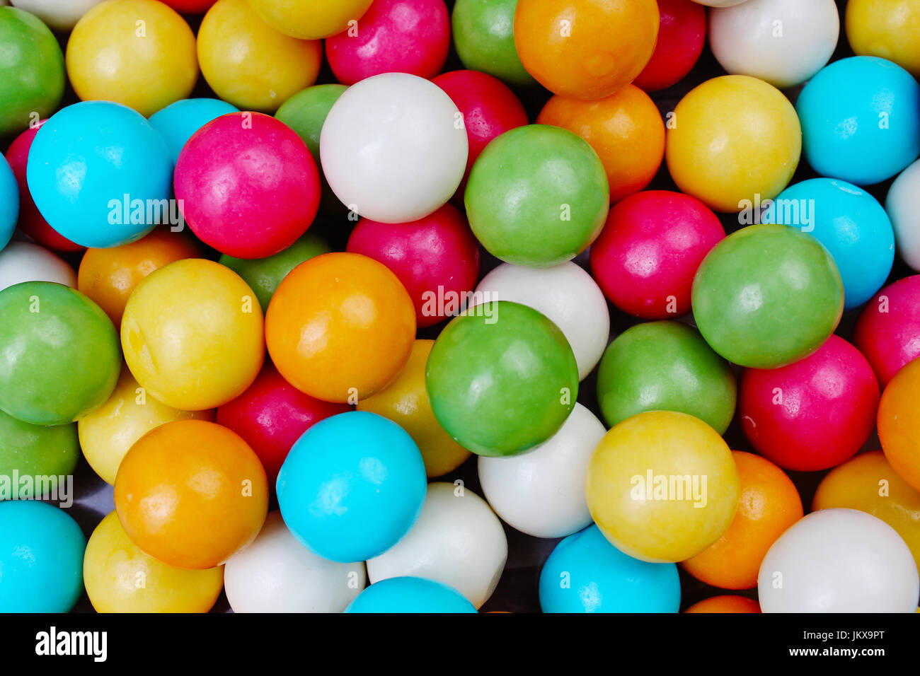 Bubble gum chewing gum texture. Rainbow multicolored gumballs chewing gums as background. Round sugar coated candy dragee bubblegum texture. Food cute Stock Photo