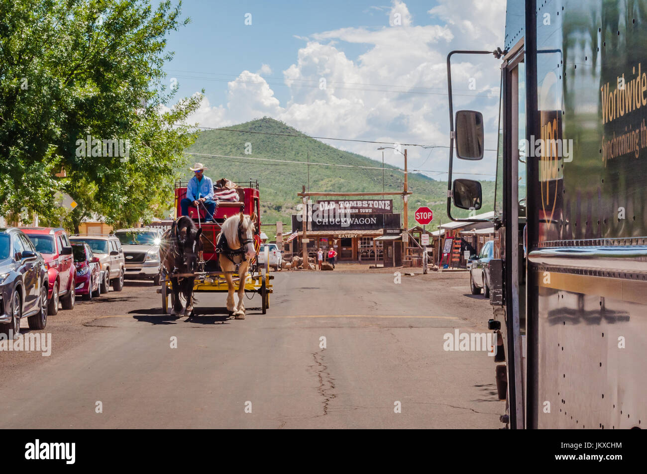 Stagecoach driver leads team of horses towards UPS delivery truck in Tombstone Arizona Stock Photo