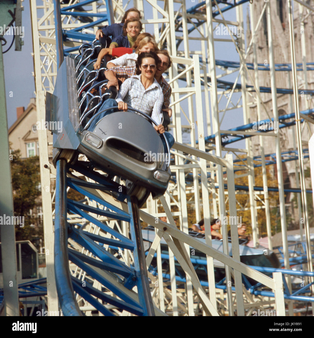 Junge Leute auf der Achterbahn auf dem Oktoberfest in München, Deutschland 1970er Jahre. Young people enjoy a ride on the rollercoaster at the Munich Oktoberfest, Germany 1970s. Stock Photo