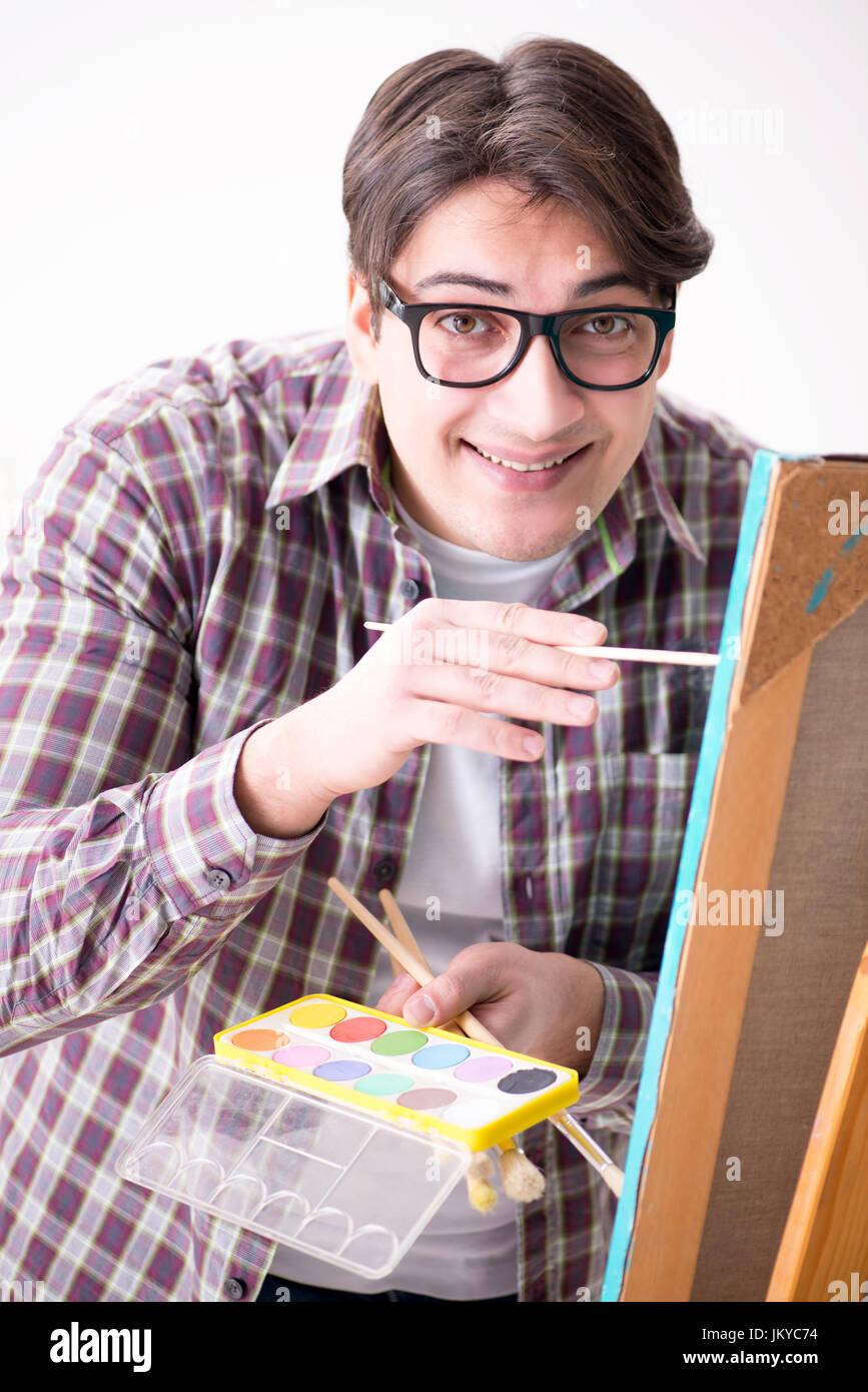 Young male artist drawing pictures in bright studio Stock Photo - Alamy