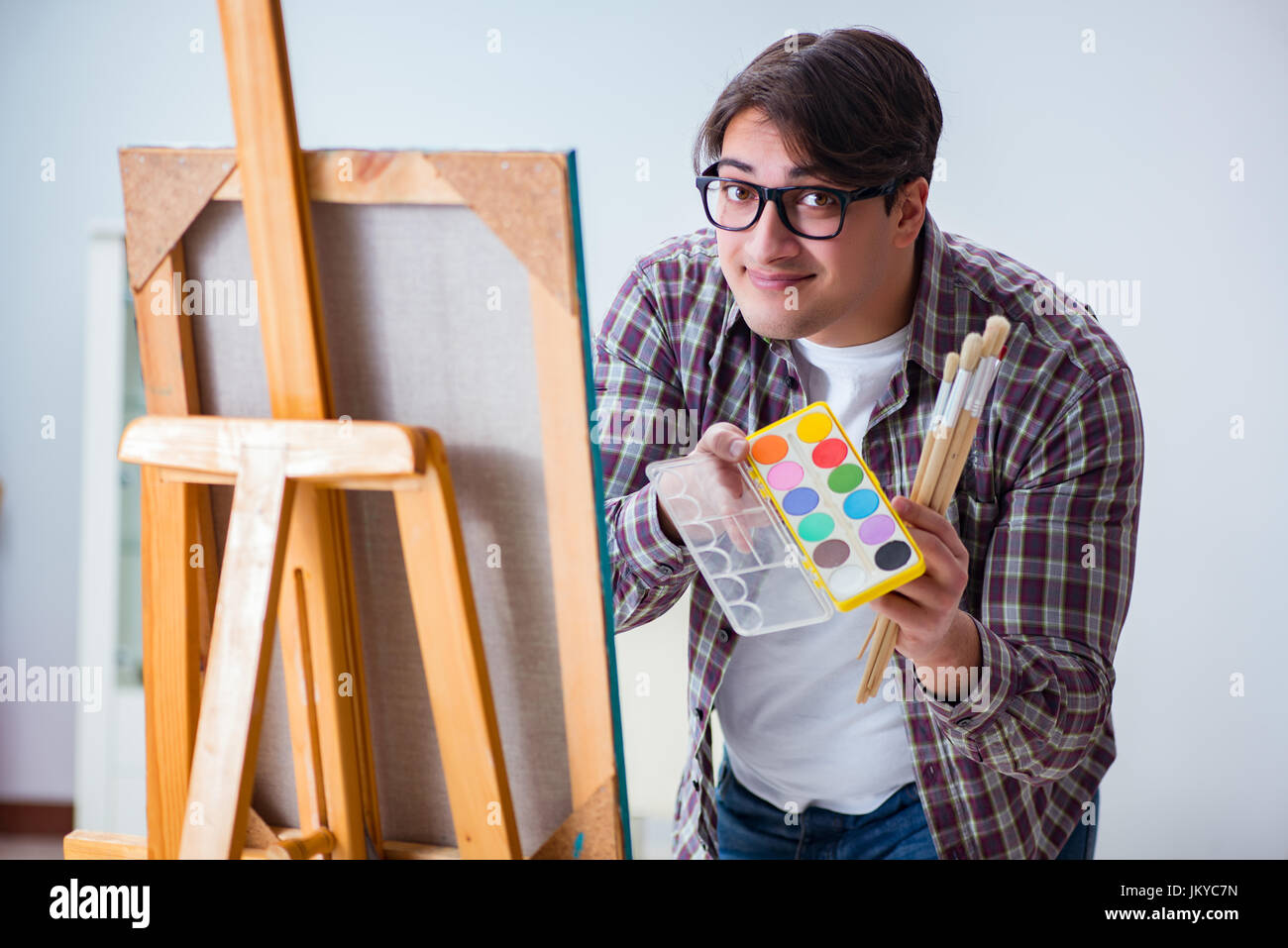 Young male artist drawing pictures in bright studio Stock Photo - Alamy