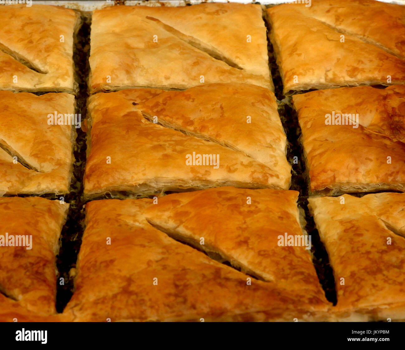 Spanakopita, also known as Spinach pie, a baked savory Greek dish made with phyllo pastry, layered with spinach and feta cheese on a baking tray Stock Photo