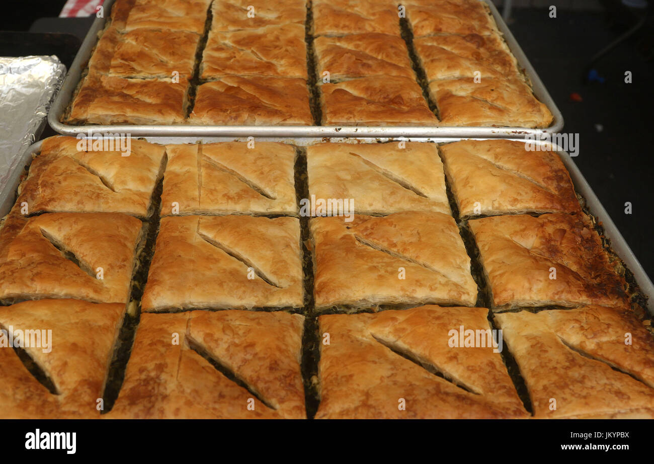 Spanakopita, also known as Spinach pie, a baked savory Greek dish made with phyllo pastry, layered with spinach and feta cheese on a baking tray Stock Photo