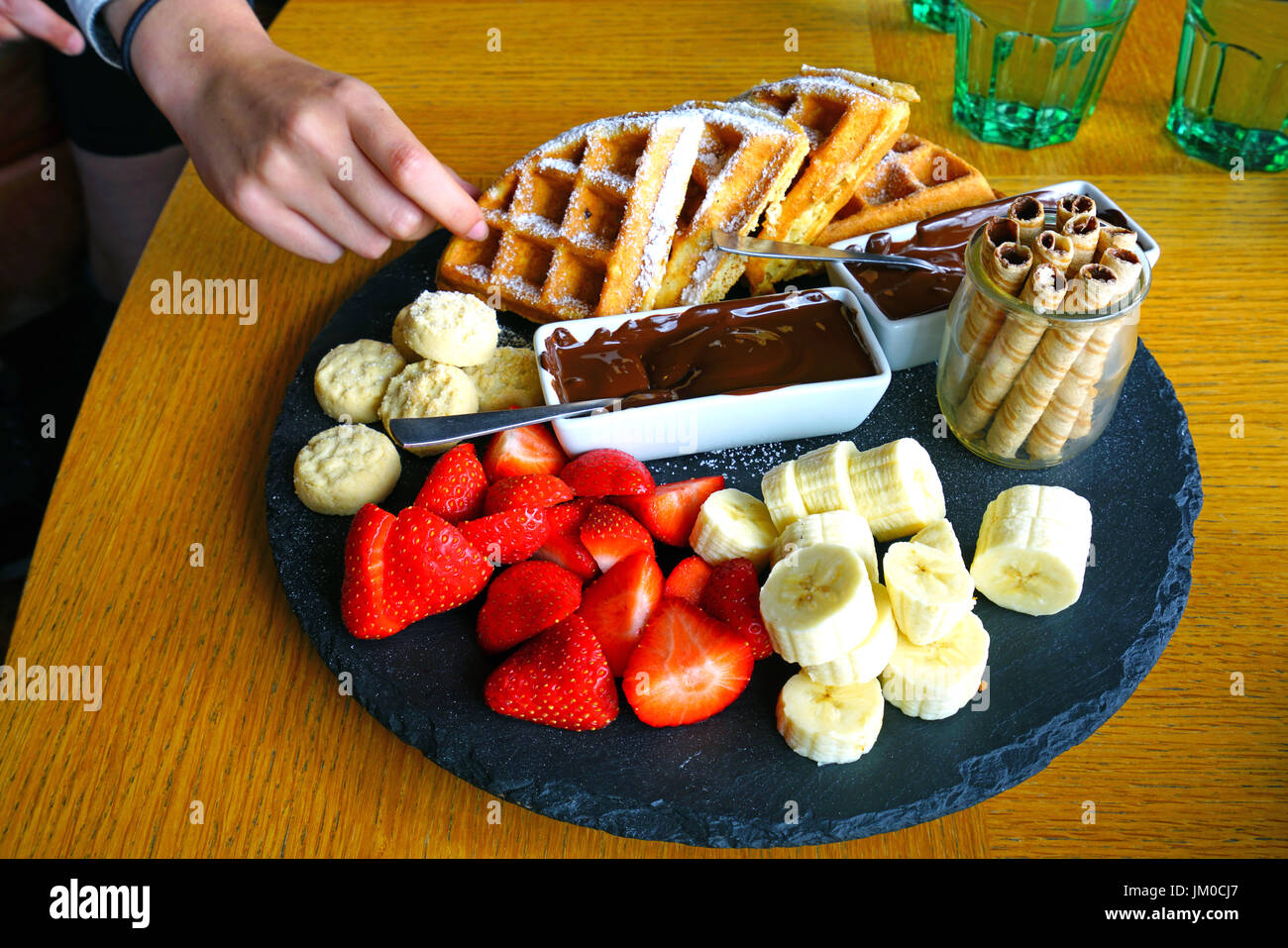 A vegan chocolate fondue platter with fresh fruit and waffles Stock