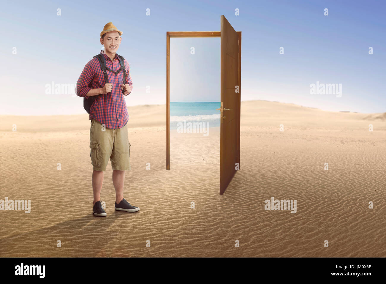 Traveler asian man going to beach on the open door at desert Stock Photo